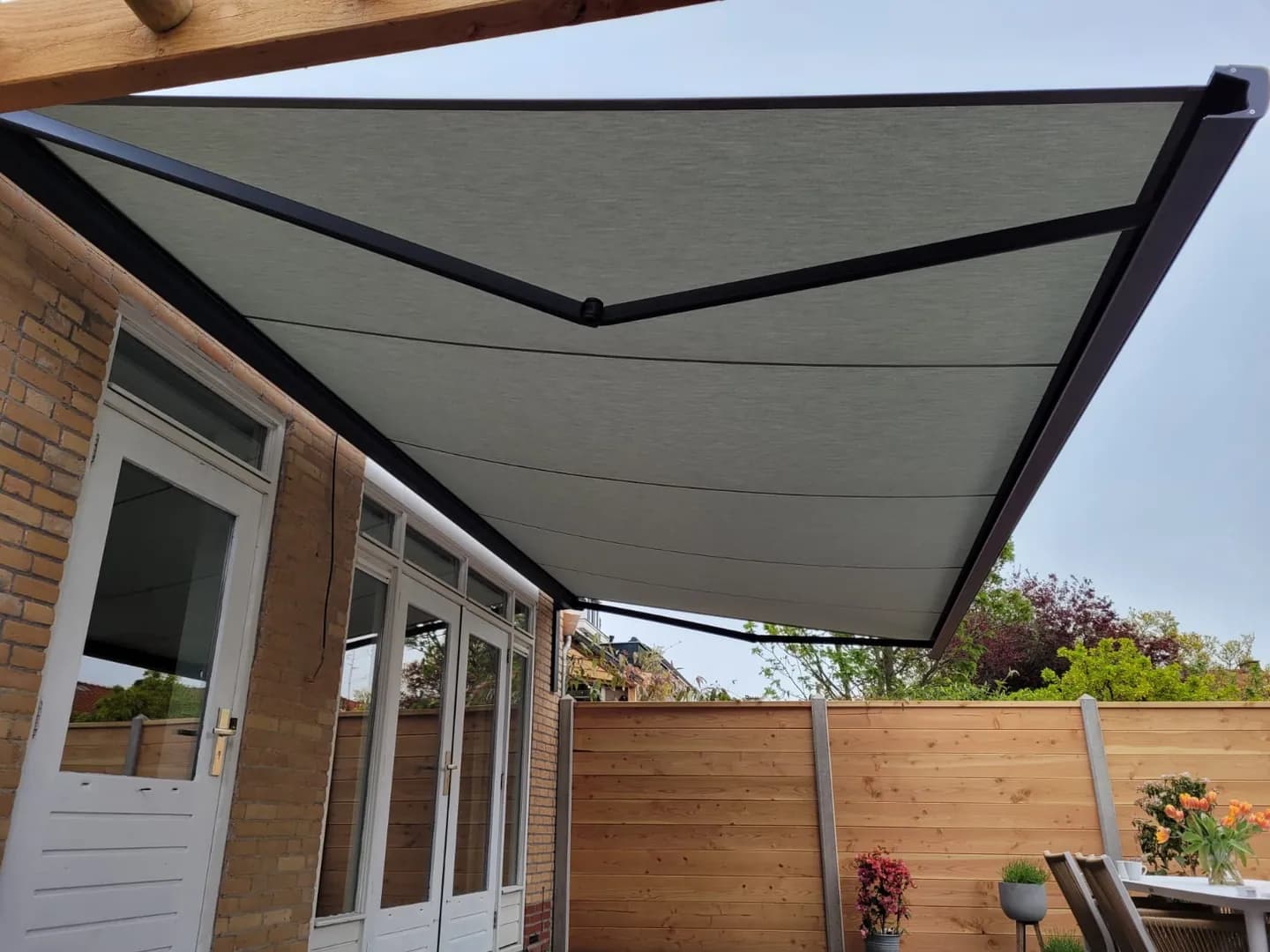 Uitgeschoven zonnescherm boven een terras