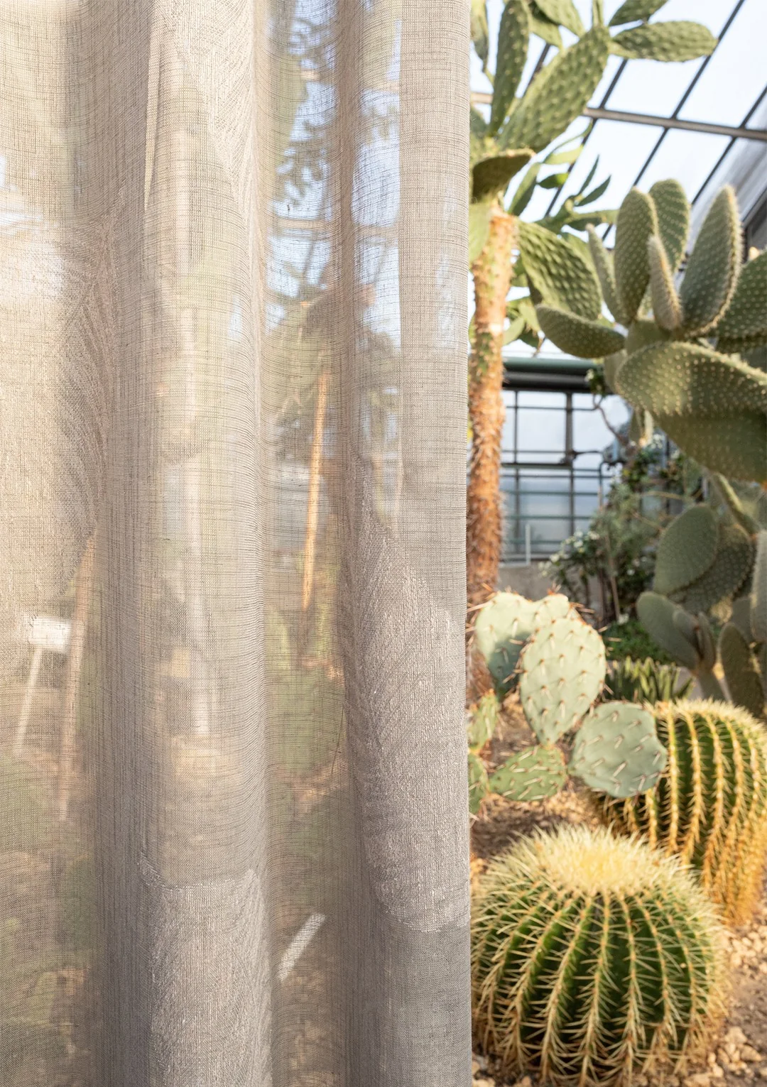 Detail van lichte gordijnstof met zicht op de tuin